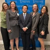 Five people standing in front of a American Association of Colleges of Nursing banner